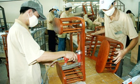 Workers craft items at a wood furniture factory. (Photo:SGGP)